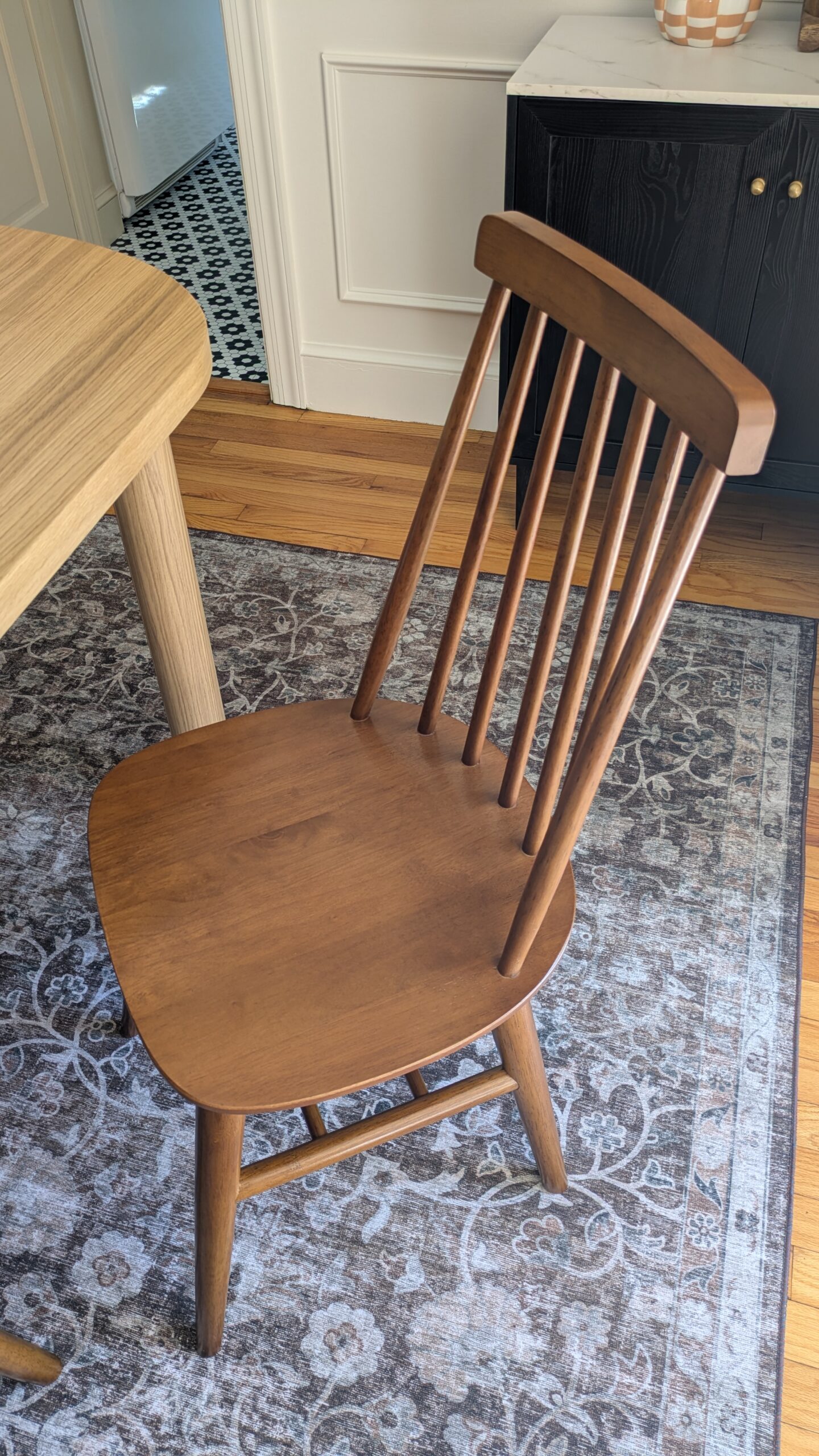 image of walnut spindle back chair and a beautiful brown tone rug.